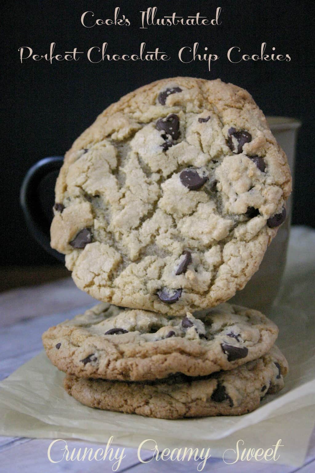 Side shot of chocolate chip cookies stacked on each other, one leaning over a cup.