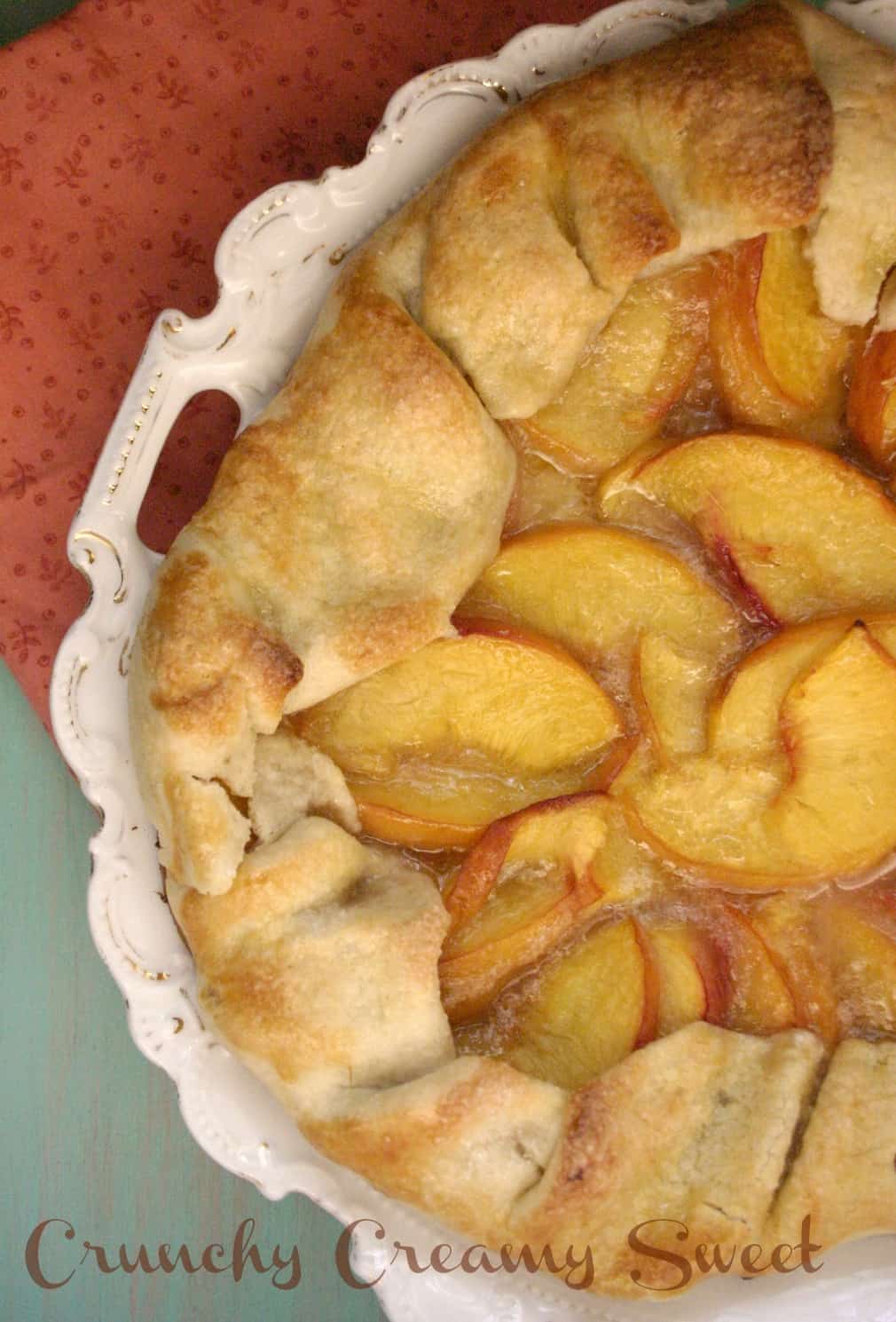 Overhead shot of peach galette on cute plate.