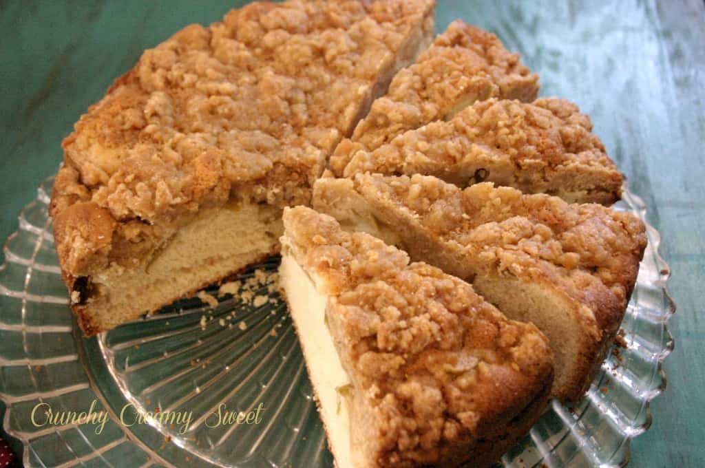 Overhead shot of slices apple coffee cake with crumb topping on cake plate.