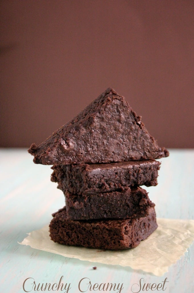 Side shot of cocoa brownies stacked up on each other.