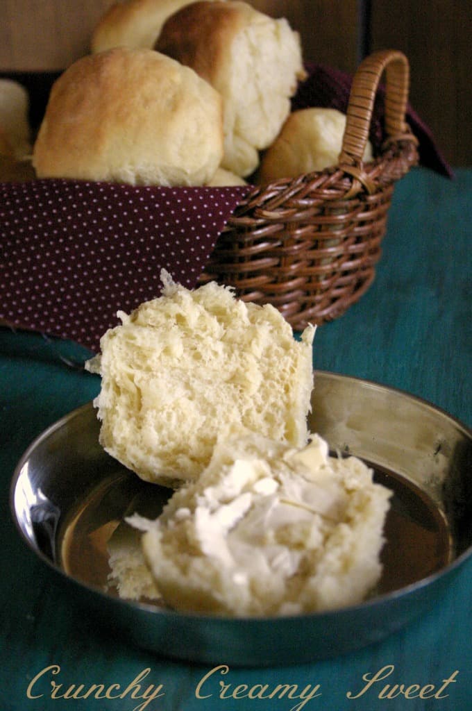 Sliced dinner roll in half, with butter.