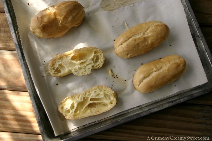 Overhead shot of baked eclair pastries on baking sheet.