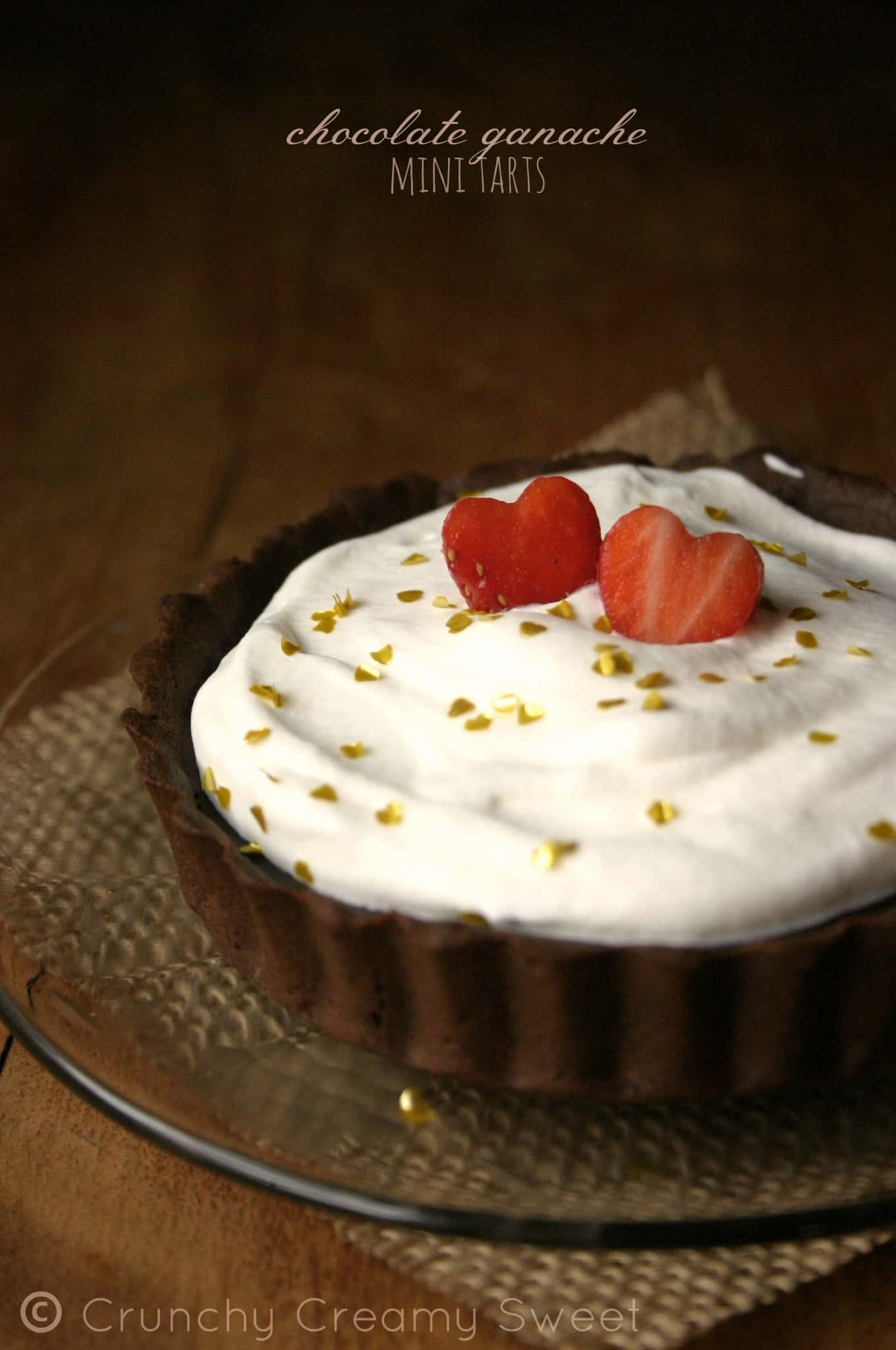 Side shot of a ganache tart with whipped cream topping.