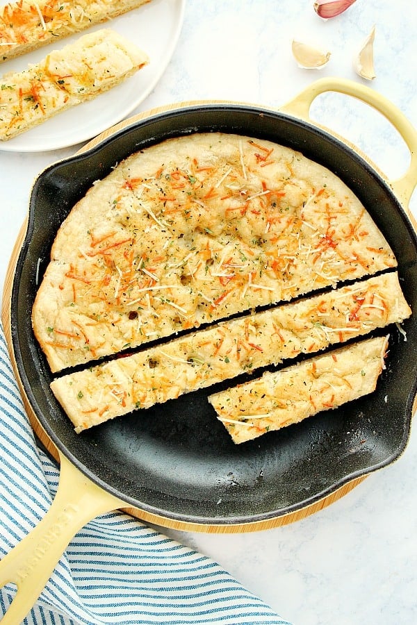 Skillet Focaccia in cast iron skillet sliced into pieces.