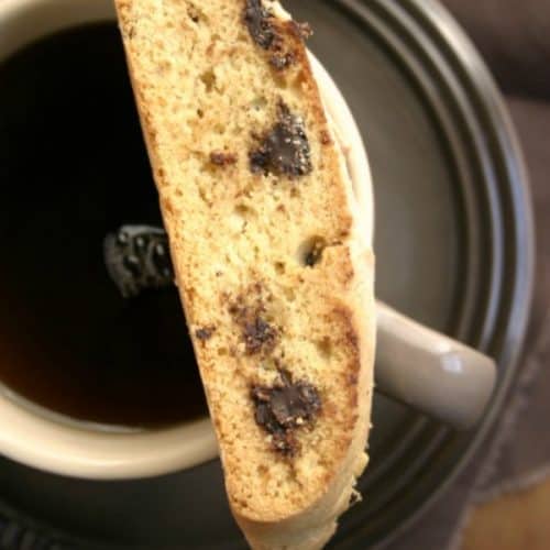 Chocolate chip biscott on top of a mug with coffee.