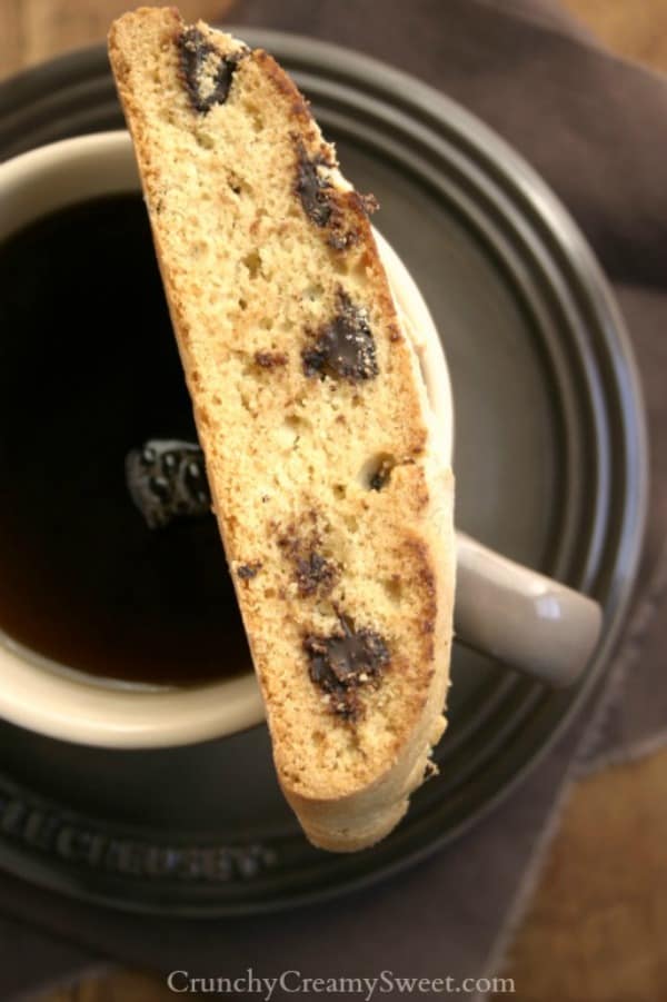 Chocolate chip biscott on top of a mug with coffee.