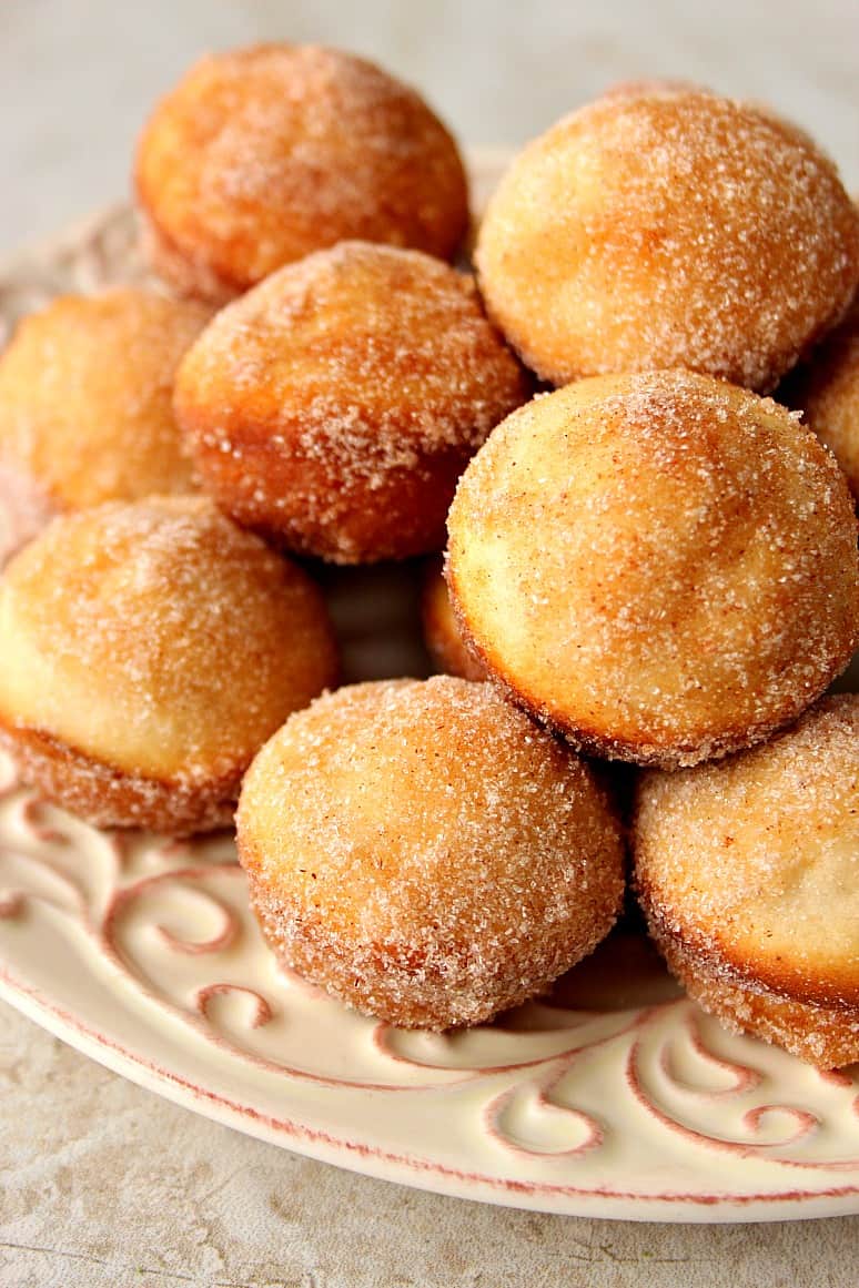 Side shot of cinnamon sugar mini donut muffins stacked up on each other.