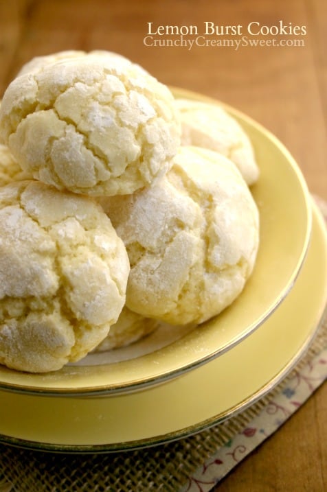 Side shot of three lemon crinkle cookies on yellow plate. 