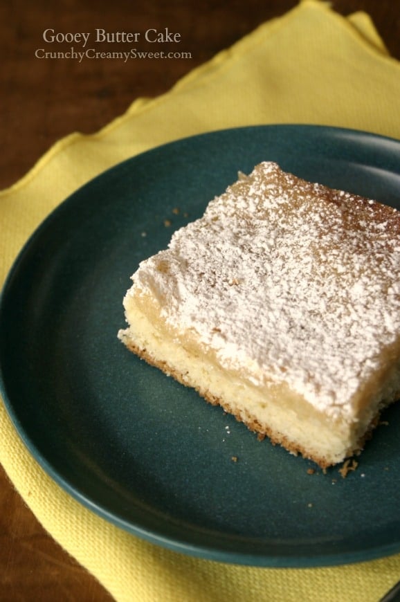 Side shot of a piece of gooey butter cake on blue plate.
