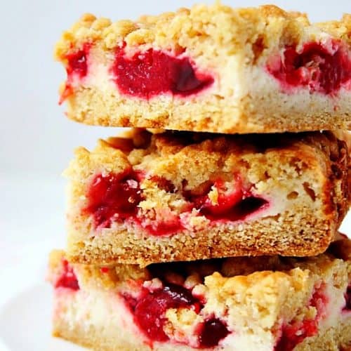 Strawberry Pie Crumb Bars stacked up on white plate.