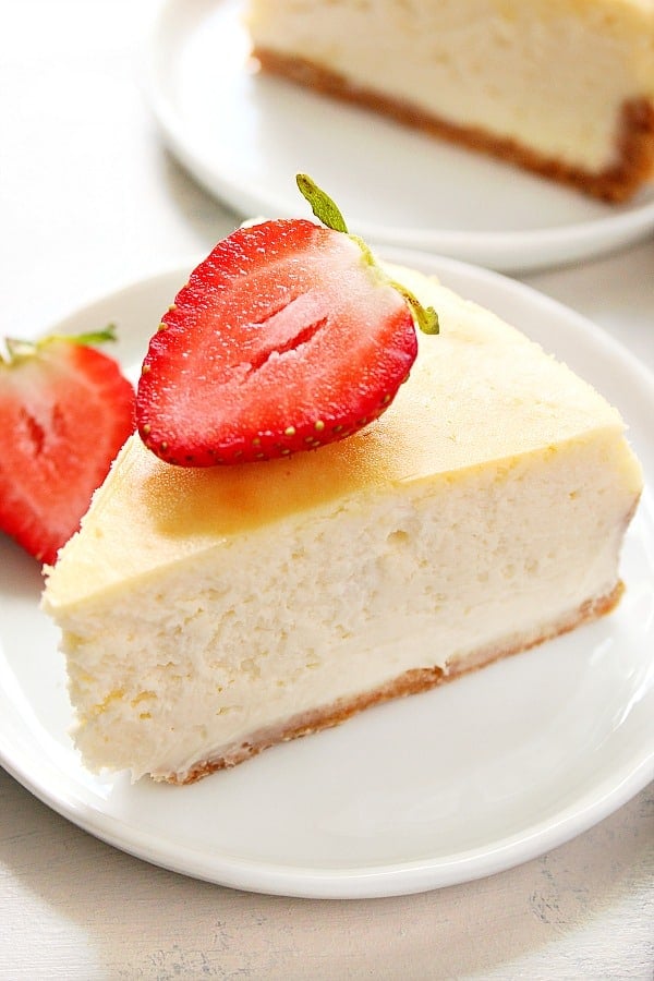 A slice of the best cheesecake on a small dessert plate.