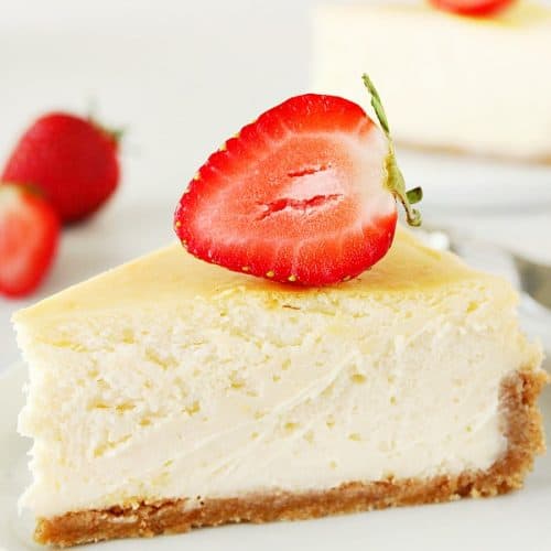 Perfect Cheesecake with strawberry on top, on white plate.