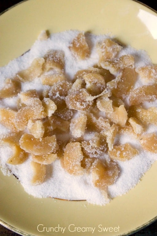Overhead shot of candied ginger in sugar on plate.