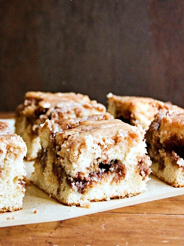 Cinnamon Roll Cake From Scratch Cake pieces on a parchment paper.