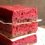 Red Velvet Cheesecake Bars stacked up.