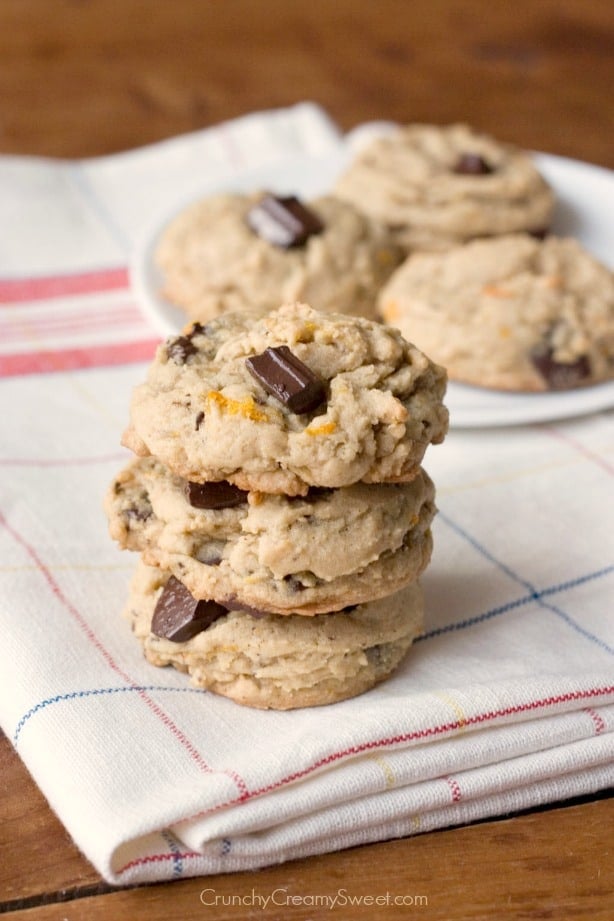 Side shot of three cookies with chocolate and orange zest stacked on each other.