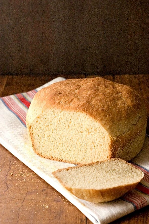 English Muffin Bread on kitchen towel, with one slice cut.