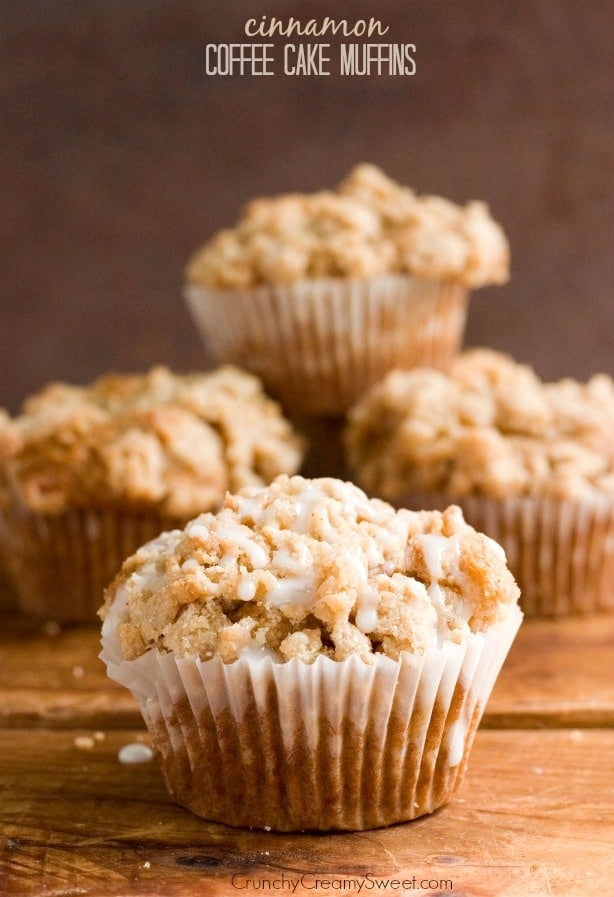 Side shot of a muffin with crumb topping on wooden board.