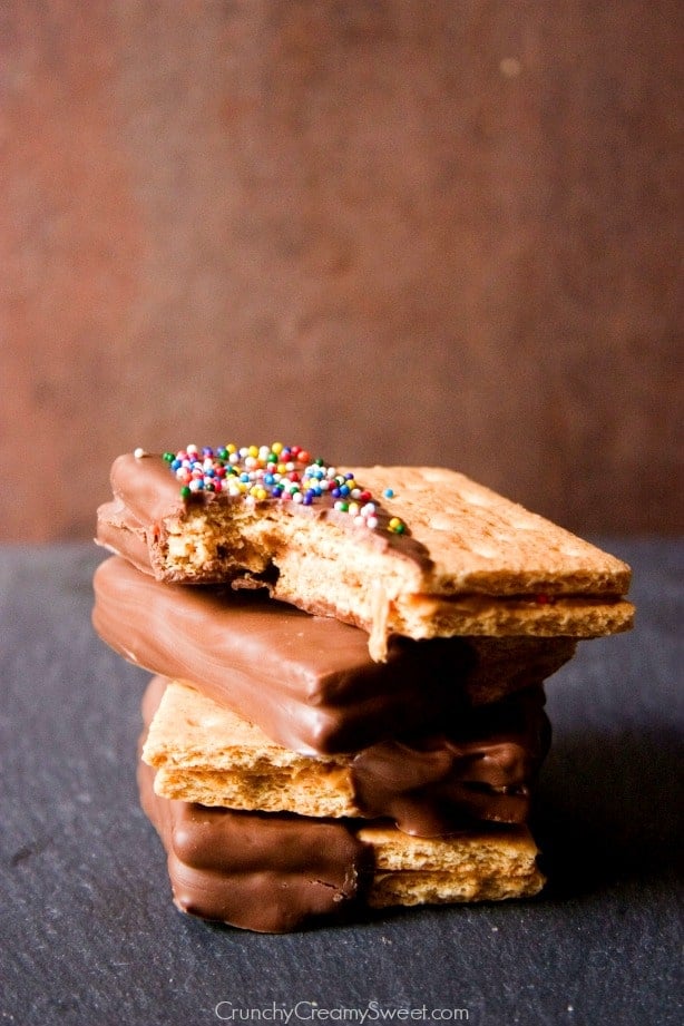 Chocolate peanut butter cracker treats in stack, one with a bite missing.
