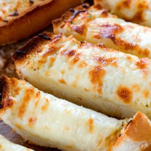 Easy cheesy Garlic Bread sliced on board.