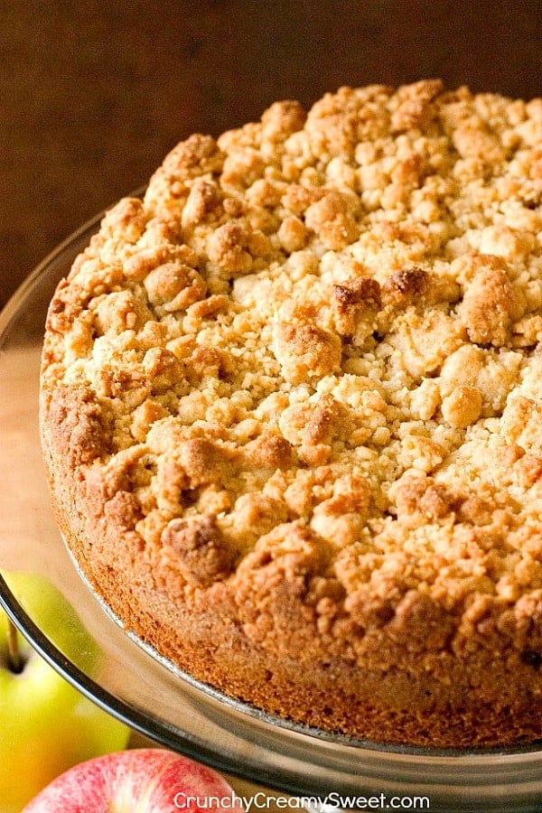 Side shot of half of crumb cake on glass cake plate.