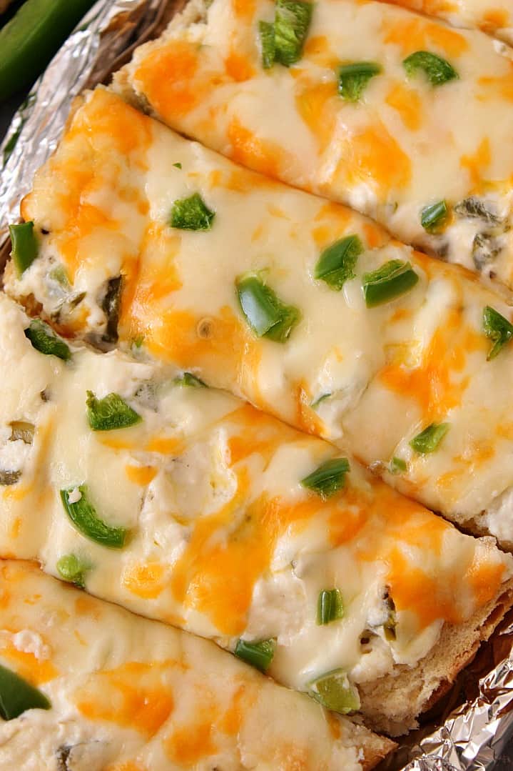 Cheesy Jalapeno Popper Bread Recipe - crispy baked bread topped with jalapeno popper mixture, cheese and fresh chopped peppers. Perfect appetizer for parties and gatherings! 