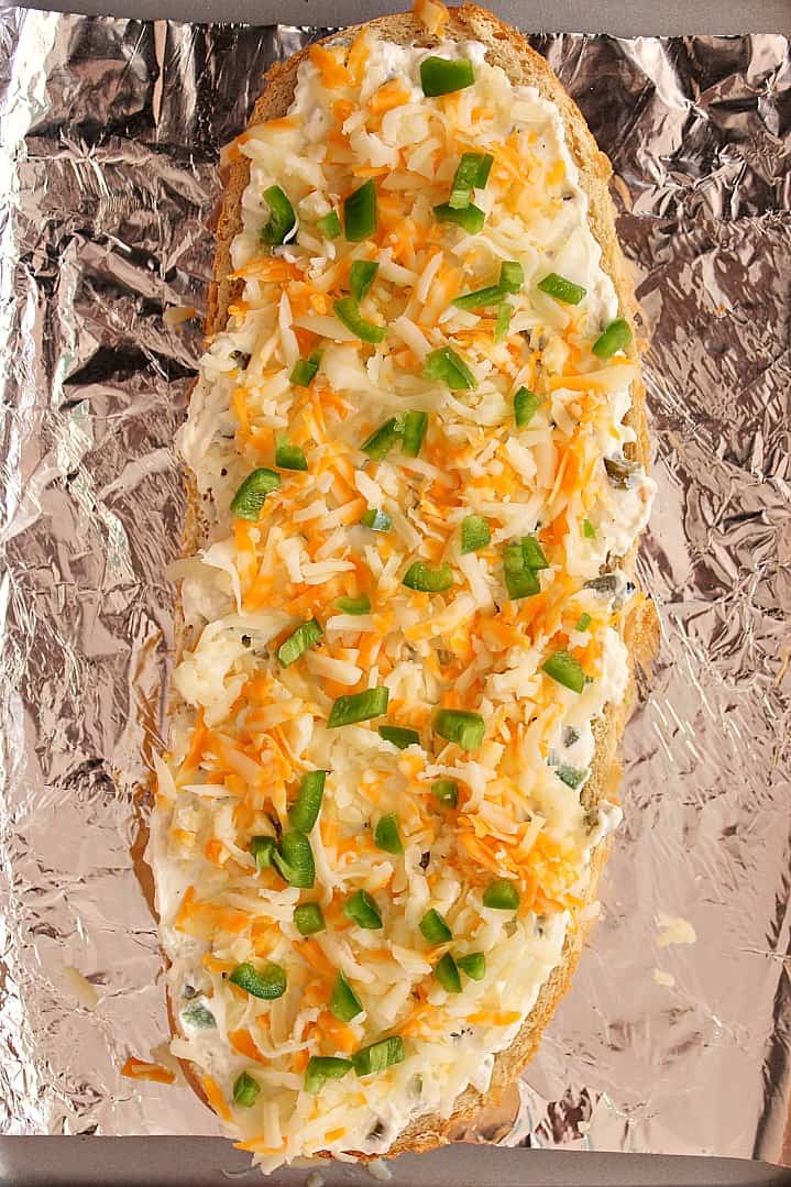 Cheesy Jalapeno Popper Bread Recipe - crispy baked bread topped with jalapeno popper mixture, cheese and fresh chopped peppers. Perfect appetizer for parties and gatherings! 