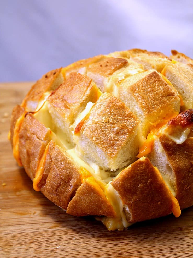 Easy Cheesy Pull Apart Bread - the easiest way to make savory pull apart bread! It's so fun to pull away chunks of bread with gooey cheese! 