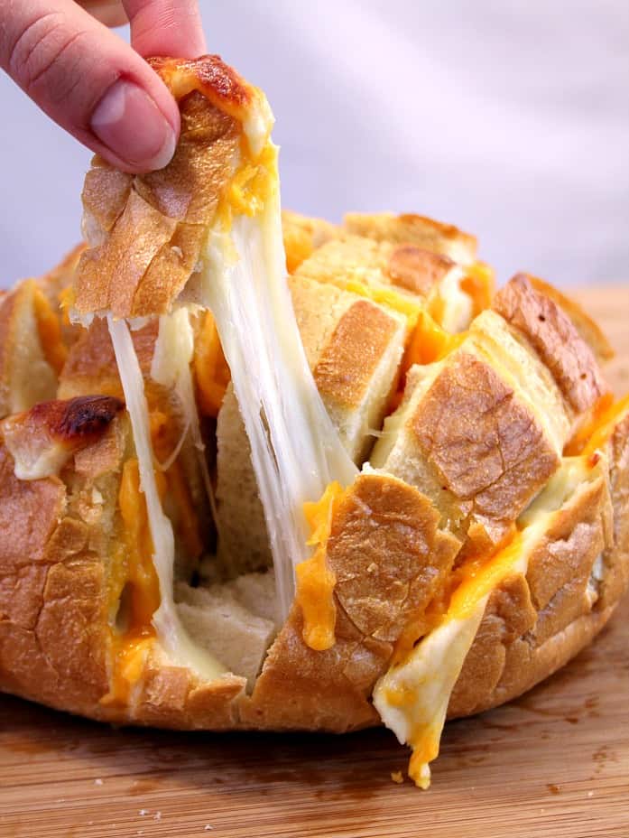 Easy Cheesy Pull Apart Bread - the easiest way to make savory pull apart bread! It's so fun to pull away chunks of bread with gooey cheese! 