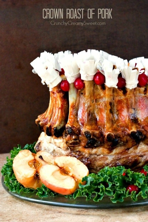 Crown Roast of Pork with paper hats on a plate with lettuce.