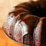 Chocolate Bundt Cake with glaze on cake stand.