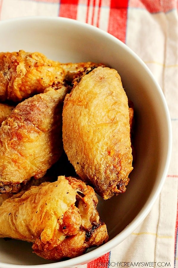 Overhead shot of crispy baked chicken wings in white bowl.