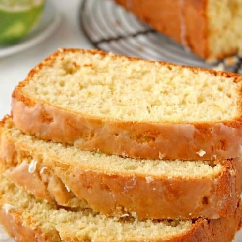 Glazed Lemon Coconut Loaf cake sliced on plate.