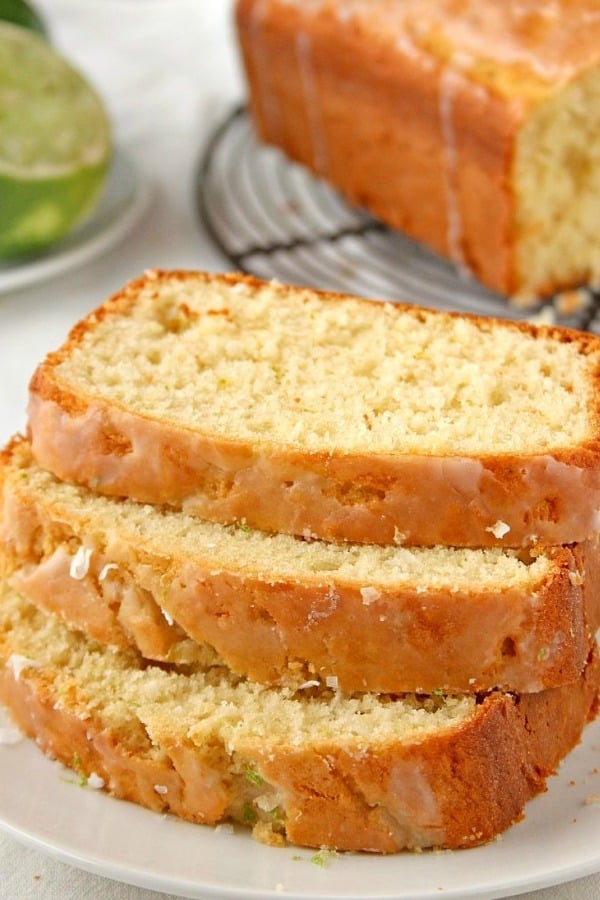 Glazed Lemon Coconut Loaf cake sliced on plate.