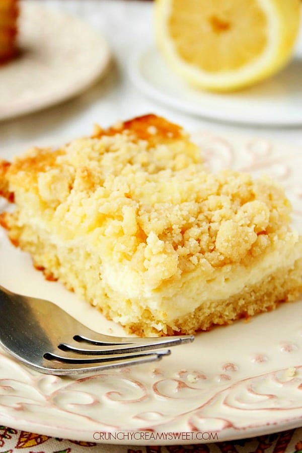 Lemon Cream Cheese Crumb Cake piece on white plate.