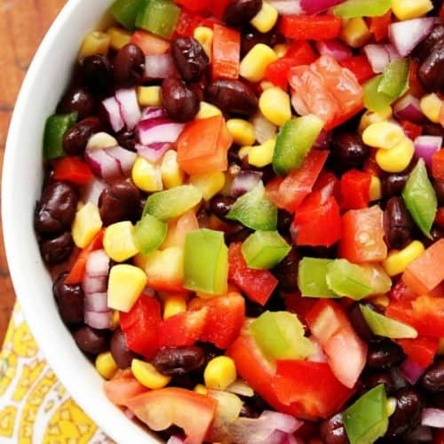 Black bean and corn salad in a white bowl on a napkin.