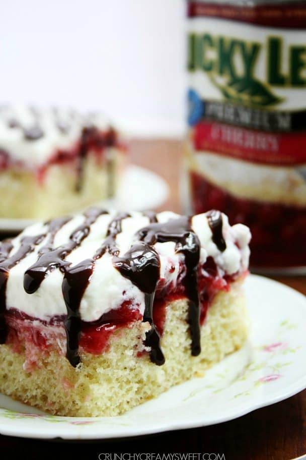 Cherry Marshmallow Delight Poke Cake - vanilla cake with cherry pie filling and marshmallow whipped cream and a drizzle of fudge sauce.