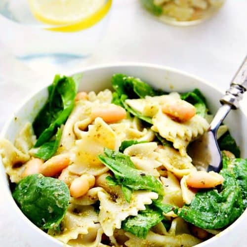 Pasta and spinach in white bowl.