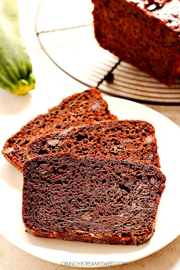 Quick Chocolate Zucchini Bread - sweet and moist chocolate bread that will quickly become your favorite way to use up the zucchini! Super easy to make and absolutely delicious! Three slices of chocolate bread on white plate.