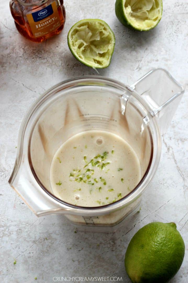 Lime and lime zest in blender jar.