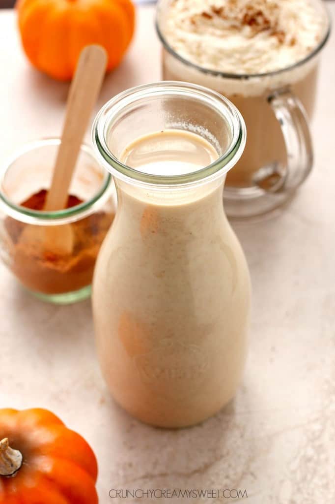 Side shot of pumpkin spice coffee creamer in glass bottle.