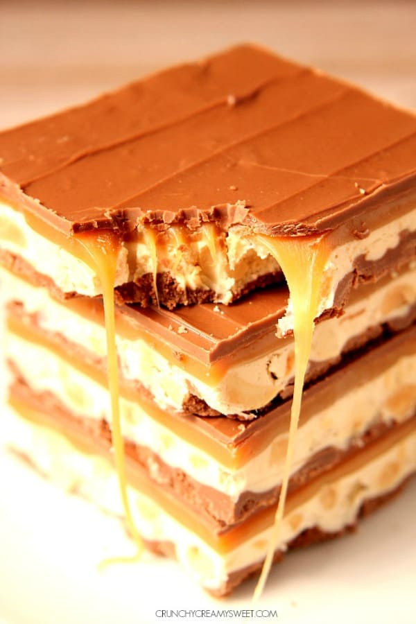 Homemade Snickers bars stacked up on each other.