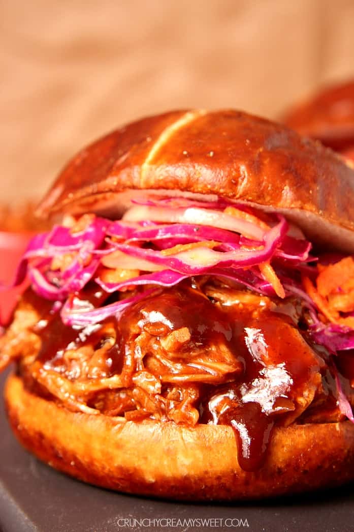 Slow Cooker Pulled Pork in a pretzel bun with coleslaw.