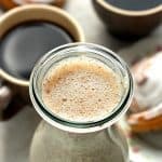 Homemade Cinnamon Roll Coffee Creamer next to coffee.