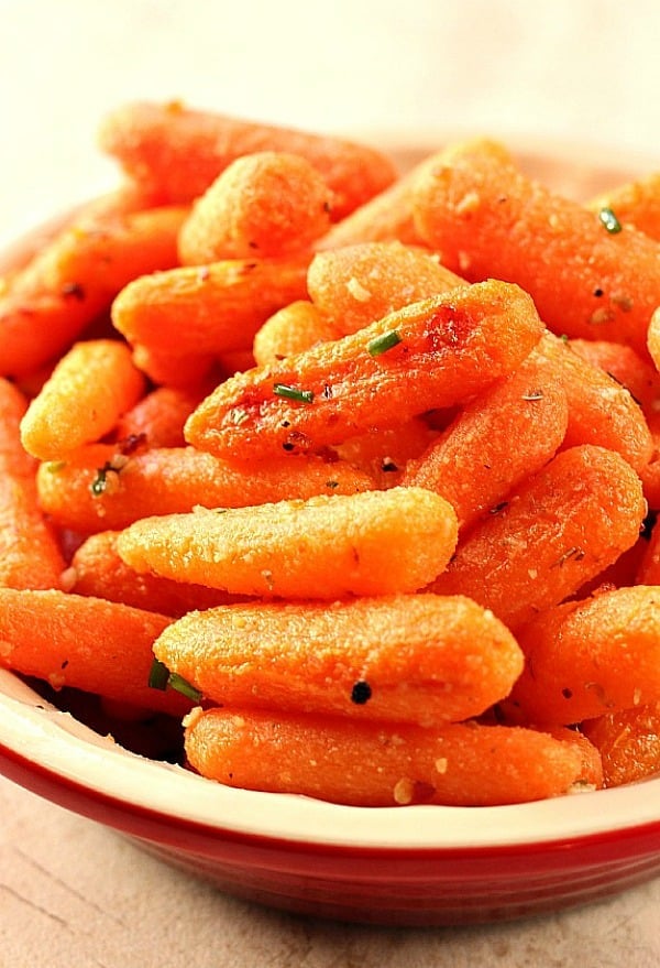 Easy Garlic Parmesan Roasted Baby Carrots - roasting carrots brings out their sweetness and rich flavor! Adding garlic, Parmesan and oregano makes them irresistible! Roasted Baby Carrots in a bowl.