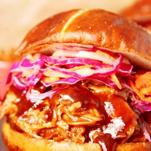 Slow Cooker Pulled Pork in a pretzel bun with coleslaw.