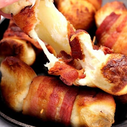 Bacon wrapped cheese bombs in small cast iron skillet.