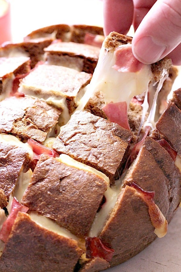 Pulling a piece of Easy Cheesy Reuben Pull Apart Bread.