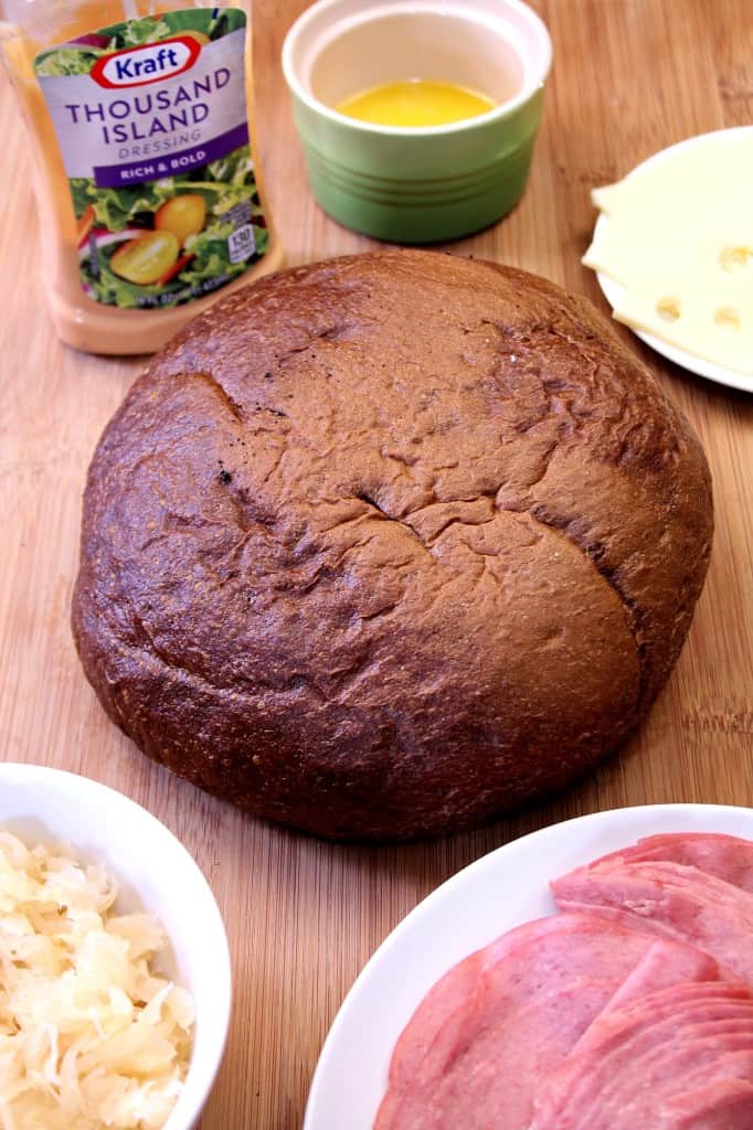 Easy Cheesy Reuben Pull Apart Bread - this one is EPIC! Pumpernickel bread filled with Thousand Island dressing, sauerkraut, corned beef and lots of cheese! Pull apart bread Reuben style! 