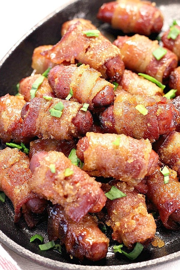 Sweet and Spicy Bacon Wrapped Little Smokies - easy party appetizer with a little bit of a sweet kick! Check out our video to see how we made them! Bacon Wrapped Little Smokies in a skillet.